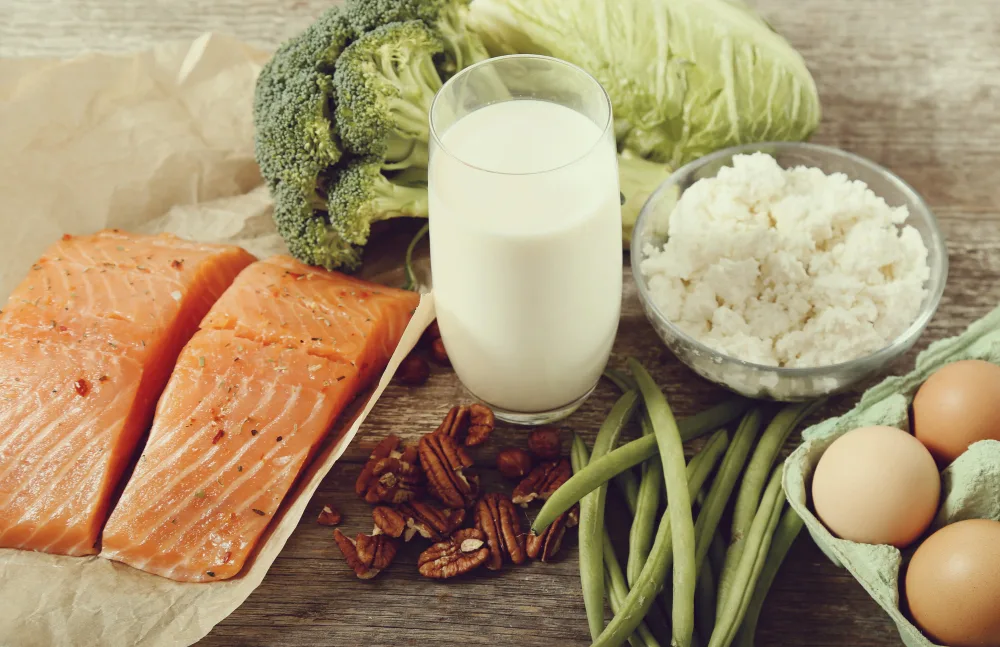 Salmon, glass of yogurt, walnuts, beans, broccoli and eggs.